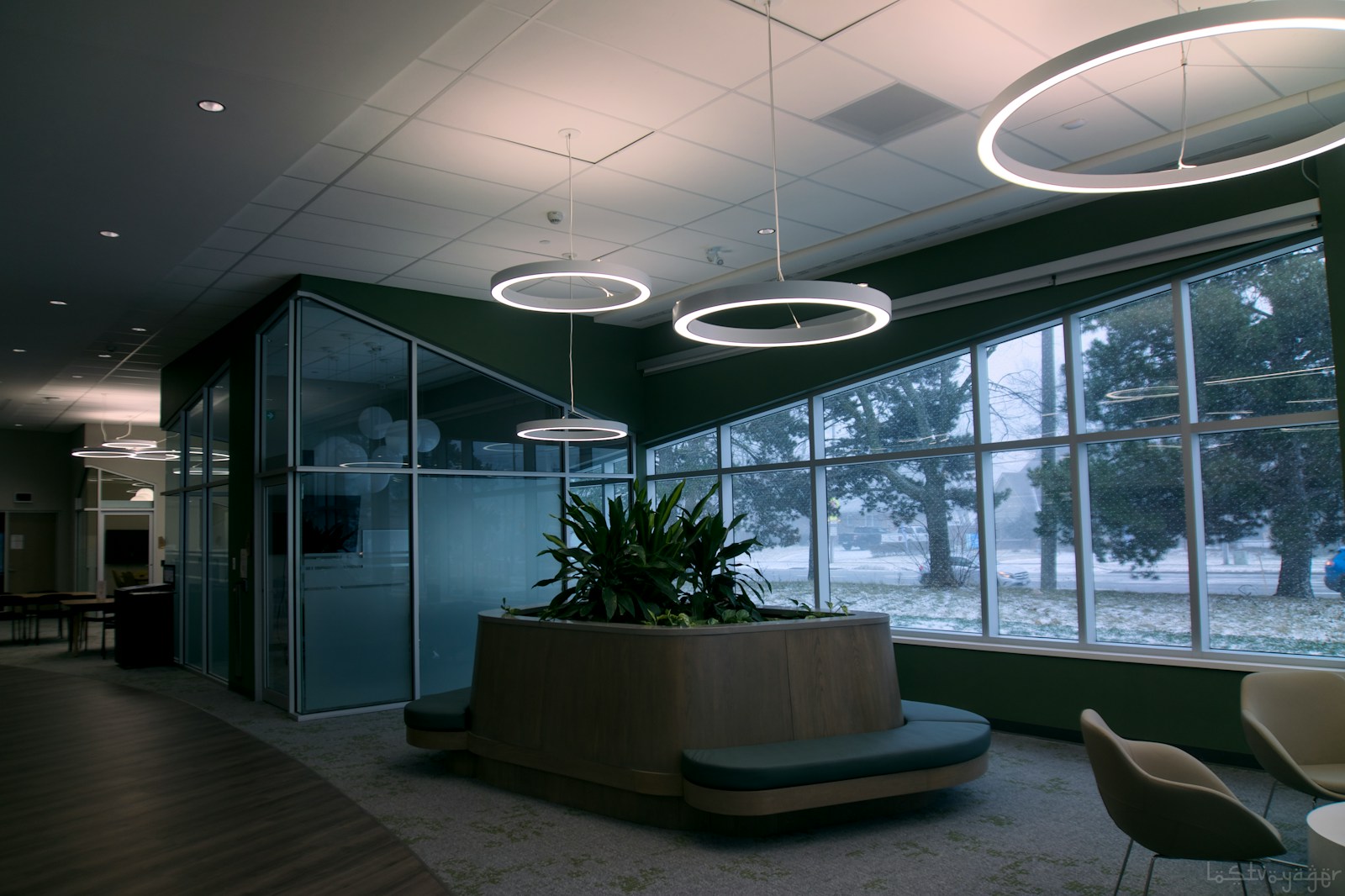 Modern office lobby with large windows and plants.